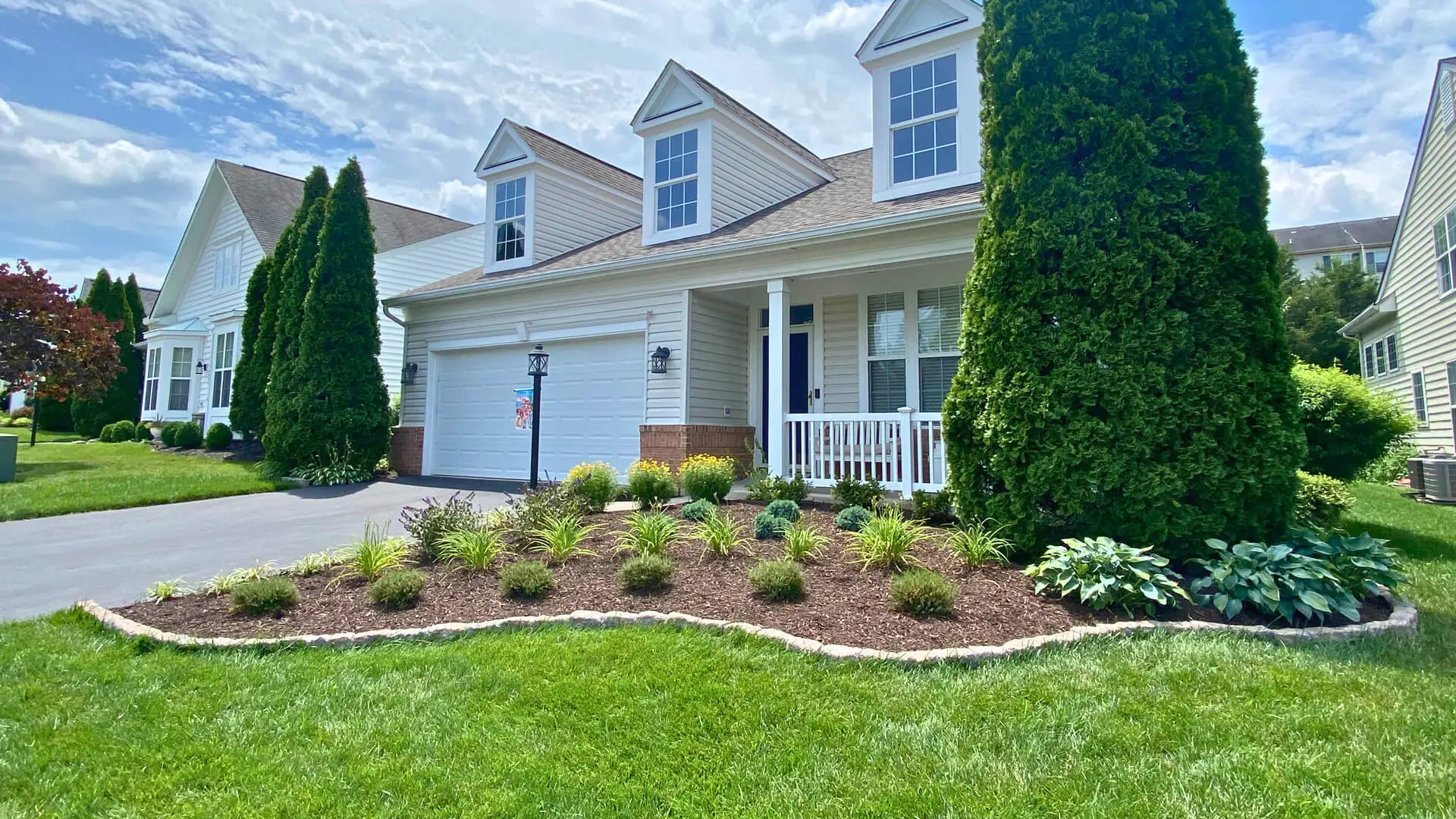 Front of a house in Bristow, VA, with a bordered landscape and plants.
