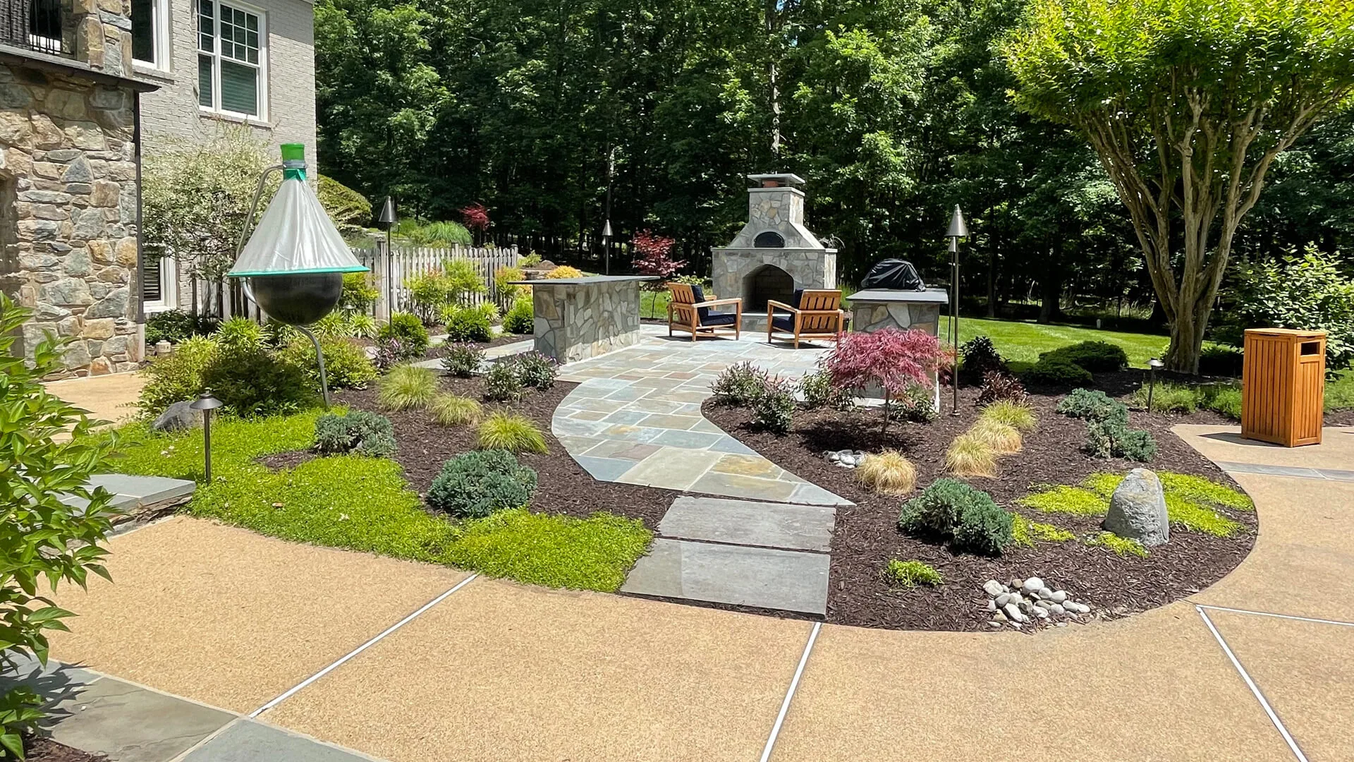 Outdoor living space in Bristow, VA, with a patio, fireplace, and kitchen.