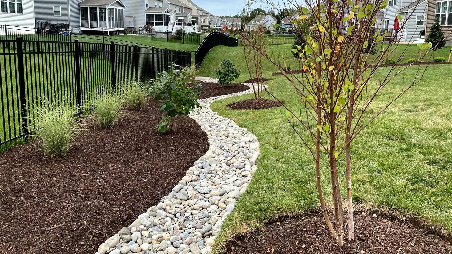 Stone creek bed in Bristow, VA, along a landscape and grass.