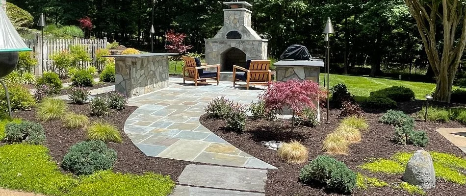 Landscape bed in Bristow, VA, with mulch, plantings, and outdoor fireplace.
