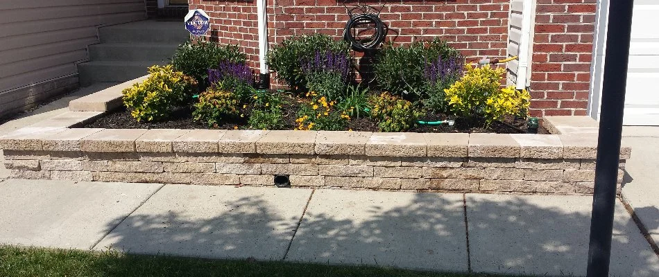 Retaining wall along a walkway in Bristow, VA, with a planter bed.