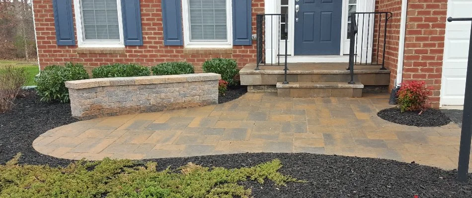 Landscaping around a small patio in Bristow, VA, with a seating wall.