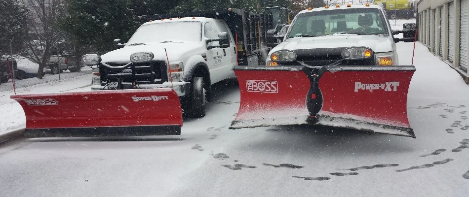 Trucks with red snow plows while it's snowing in Bristow, VA.